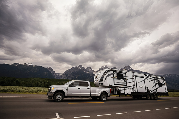 4x4 vehicle towing caravan through rural mountain region