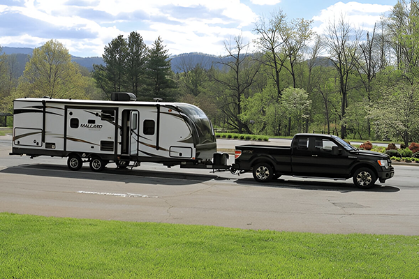 4x4 vehicle towing caravan through countryside