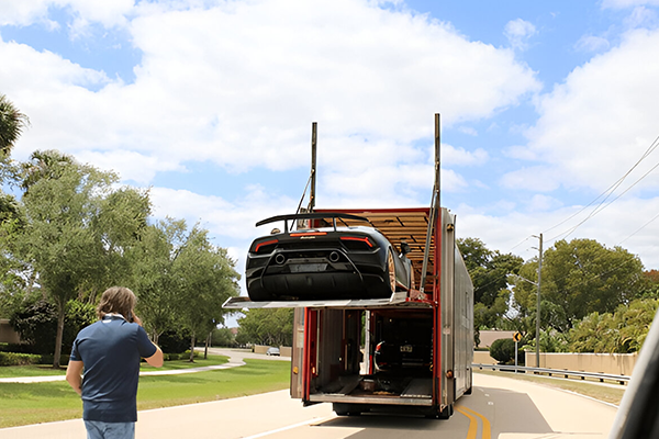 Supercar lifted into two-storey enclosed car transporter