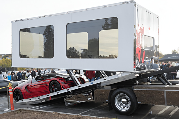Performance cars secured inside white enclosed carrier